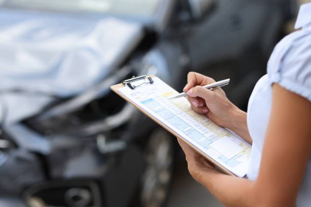 insurance agent inspects damaged vehicle. car insurance concept